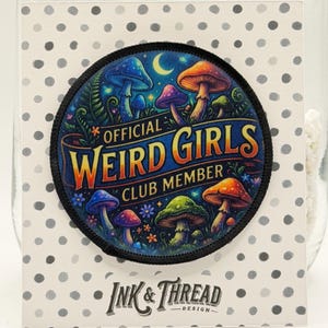 May include: A circular patch with a black border, displaying vibrant mushrooms, a crescent moon, and the words "OFFICIAL WEIRD GIRLS CLUB MEMBER." The patch is set against a polka dot background, with the "Ink & Thread Design" logo at the bottom.