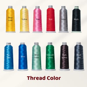 May include: Twelve spools of thread in a range of colours: Deep Gold, Yellow, Pink, Red, Silver, Black, Sky Blue, Blue, Mint Green, Emerald Green, Dark Brown, and Dark Grey. The words "Thread Color" are displayed at the bottom.