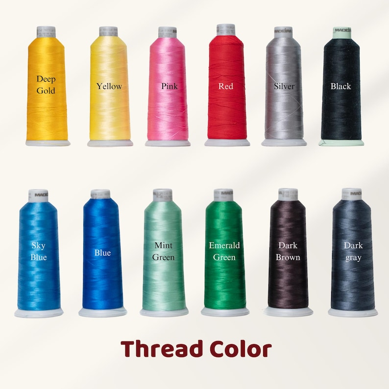 May include: Twelve spools of thread in a range of colours: Deep Gold, Yellow, Pink, Red, Silver, Black, Sky Blue, Blue, Mint Green, Emerald Green, Dark Brown, and Dark Grey. The words "Thread Color" are displayed at the bottom.