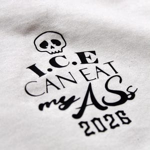 May include: White fabric with a black skull graphic and the text "I.C.E. CAN EAT my ASs 2026". The design features a skull above the text. The text is in a bold, stylized font.