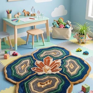 May include: A colorful rug with a crystal design in a child's playroom. The rug features shades of blue, green, brown, and orange. The room also includes a small table, chairs, toys, and a dinosaur-shaped planter.