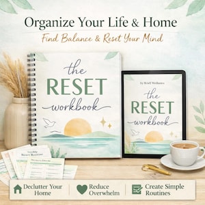 May include: A spiral-bound workbook and a tablet display the title "The Reset Workbook" with a sunrise illustration. The image includes a vase with dried plants, a cup of coffee, and a pen. Text at the top reads "Organize Your Life & Home."