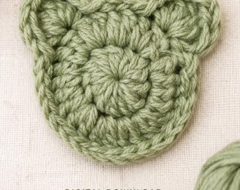 Könnte beinhalten: Eine salbeigrüne Häkelapplikation in Form eines Tiergesichts mit abgerundeten Ohren und einer kreisförmigen Mitte. Das Bild enthält den Text: CROCHET PATTERN, DIGITAL DOWNLOAD, Animal Face Applique, CUTE QUICK BEGINNER FRIENDLY.
