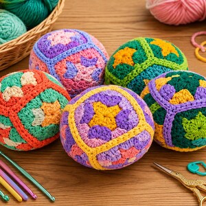 Puede incluir: Una colecci&oacute;n de esferas de ganchillo coloridas en varios colores, incluyendo naranja, morado, verde y amarillo. Las esferas est&aacute;n dispuestas sobre una superficie de madera, con ganchos de ganchillo, hilo y una cesta de hilo en el fondo.