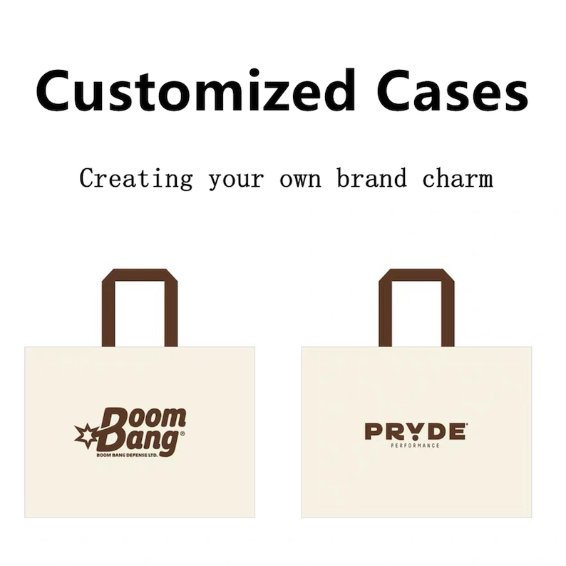 May include: Two off-white rectangular tote bags with brown handles. The left bag features a brown logo reading "Boom Bang" with a star icon and "BOOM BANG DEFENSE LTD." text. The right bag displays the brown text "PRYDE PERFORMANCE".