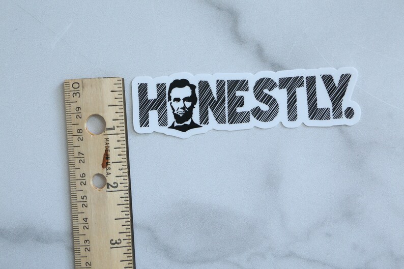 May include: A white sticker with black text that reads "HONESTLY."  A black and white image of Abraham Lincoln is in the "H".