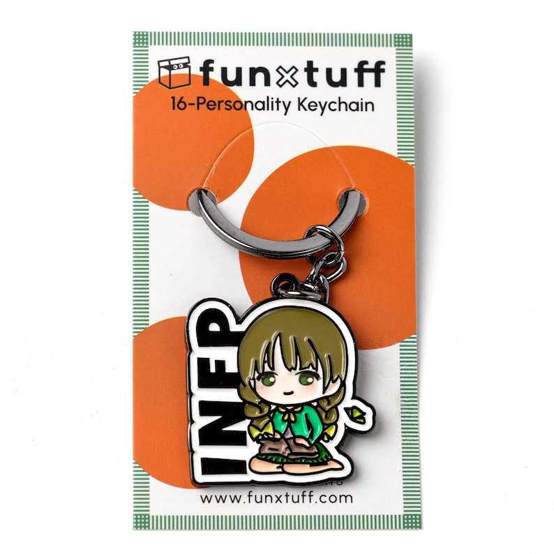 May include: A metal keychain featuring a chibi-style character with brown hair and a green cardigan, sitting and holding a book. The charm is attached to a silver ring on a white backing card with orange circles and the text funxtuff 16-Personality Keychain.
