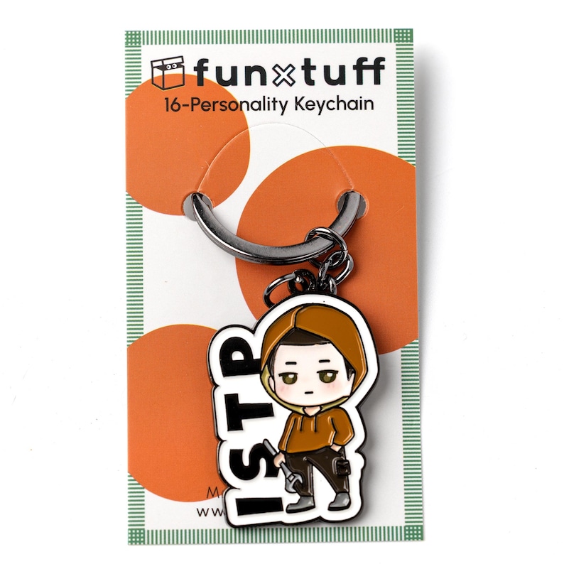 May include: A metal keychain featuring a cartoon character wearing a brown hoodie and dark pants, holding a wrench. The character is next to the text ISTP. The keychain is attached to a white display card with orange circles and the text funxtuff.
