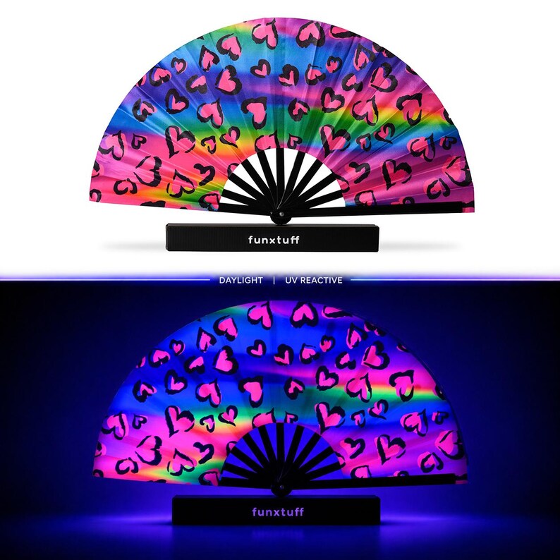 May include: A folding hand fan with a rainbow gradient background and black heart outlines. The fan features black ribs and a black base with the text funxtuff printed in white. The bottom section shows the fan glowing under UV light.