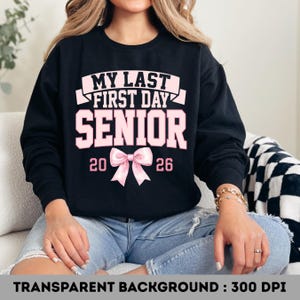 May include: Black sweatshirt with the text "MY LAST FIRST DAY SENIOR 2026" in pink. A pink bow is centered below the text. The sweatshirt is a senior year graduation design.