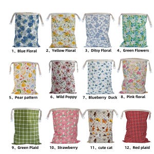 May include: A collection of twelve rectangular fabric drawstring bags featuring various patterns including blue floral, yellow floral, ditsy floral, green flowers, pear, wild poppy, blueberry duck, pink floral, green plaid, strawberry, cat, and red plaid.