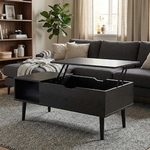 Könnte beinhalten: Ein schwarzer Couchtisch mit Hubtischfunktion und verstecktem Stauraum. Der Tisch hat eine rechteckige Platte, die sich anheben lässt und einen Stauraum freigibt. Der Tisch wird von vier schwarzen Beinen getragen.