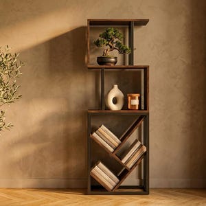 May include: A modern, dark wood bookshelf with a bonsai tree, a white vase, and a small candle. A potted olive tree stands to the left. The room has a neutral color palette with a window and sheer curtains.