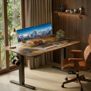 May include: A home office setup featuring a brown adjustable desk with two computer monitors displaying a mountain landscape. A brown leather office chair, headphones, and a desk lamp are also present. The room has wooden paneling and a large window.