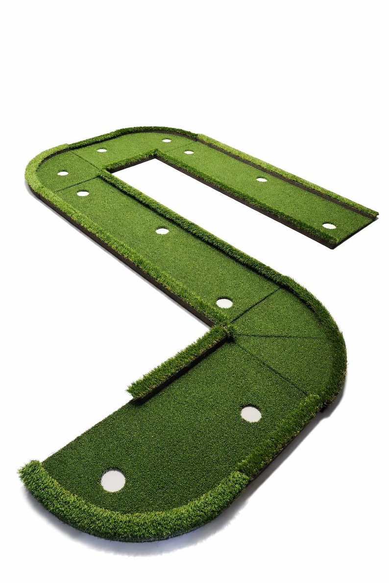 Puede incluir: Un green de golf artificial verde con un dise&ntilde;o curvo en forma de S. El green tiene varios hoyos blancos y est&aacute; bordeado por un borde verde m&aacute;s oscuro. El green est&aacute; dise&ntilde;ado para la pr&aacute;ctica del golf en interiores o exteriores.