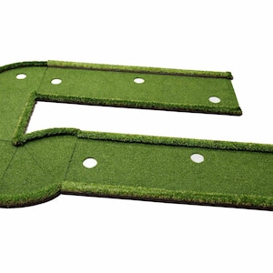 Puede incluir: Un green de golf artificial verde en forma de L con m&uacute;ltiples hoyos blancos. El green est&aacute; dise&ntilde;ado para uso en interiores o exteriores. Est&aacute; hecho de c&eacute;sped artificial y tiene una esquina curva.