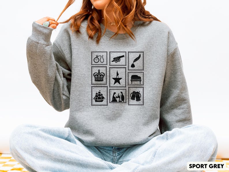 Puede incluir: Sudadera gris deportiva con un dise&ntilde;o de sellos negros. Los sellos representan una bicicleta, un ca&ntilde;&oacute;n, una pluma, una corona, una estrella, un piano, un barco, figuras y jarras de cerveza. El texto "SPORT GREY" est&aacute; en la parte inferior derecha.
