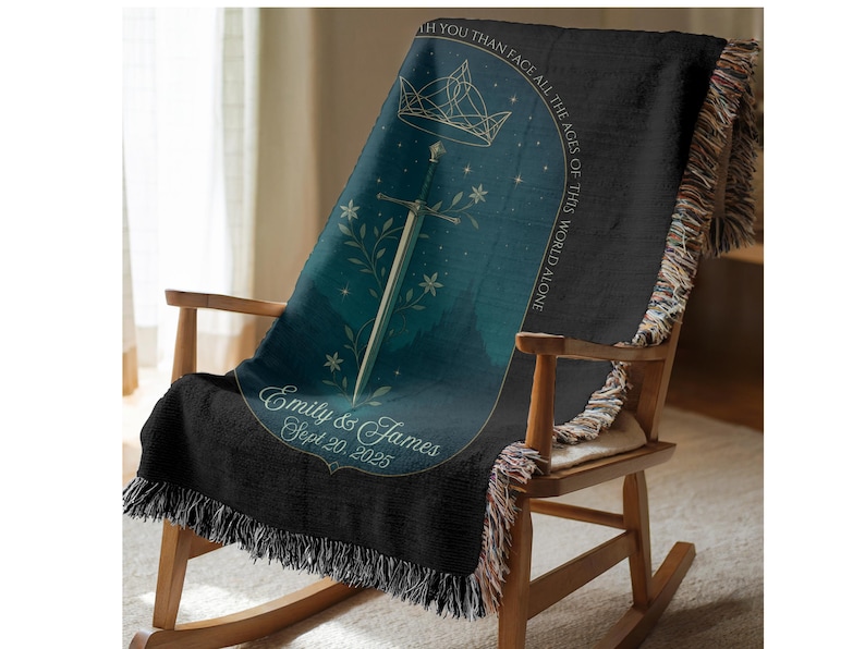 Op de afbeelding: Een zwarte sprei met een teal en marineblauw ontwerp, gedrapeerd over een houten schommelstoel. De sprei heeft een zwaard, een kroon en bloemmotieven. Tekst bevat "Emily & James Sept 20, 2025" en "I'd rather face all the ages of this world alone."