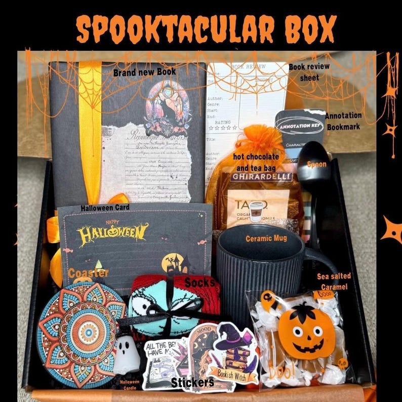May include: A Halloween-themed gift box filled with a book, mug, socks, stickers, hot chocolate, and other treats. The box includes a Halloween card and a coaster. The text "SPOOKTACULAR BOX" is at the top.