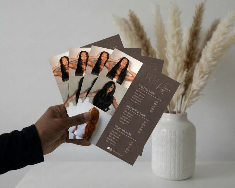 A warm neutral lifestyle shot showing hands holding the printed dark brown luxury price list alongside dried pampas grass and a soft beige background representing the premium printed finish of the luxury hair salon service menu template giving wig seller, extension brand, and beauty professional a visual of how polished their printed price list will look