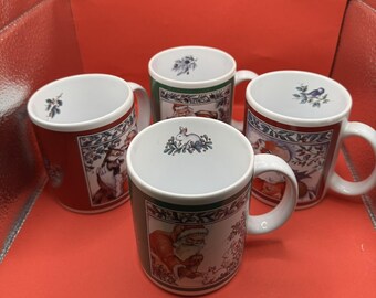 May include: Four ceramic mugs with white interiors and handles. Each mug features a different Christmas-themed illustration, including Santa Claus, a fox, and a bird. The mugs have red and green borders with decorative patterns.