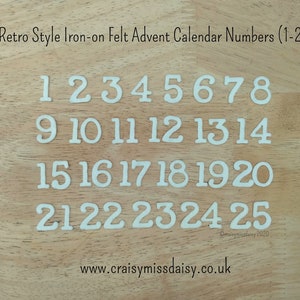 May include: White felt iron-on numbers 1-25 in a retro style, ideal for an advent calendar. The numbers are displayed on a light wood surface. The text "Retro Style Iron-on Felt Advent Calendar Numbers (1-25)" is at the top.