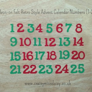 May include: A set of iron-on felt numbers from 1 to 25 in alternating red and green colors. The text "Iron-on Felt Retro Style Advent Calendar Numbers (1-25)" and "www.craisymissdaisy.co.uk" are printed on the image along with the numbers.