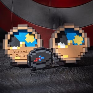 Puede incluir: Accesorios de diseño pixelado, que incluyen dos piezas redondas de pixel art marrón y azul y un pequeño llavero pixelado negro. El texto "Customize Content" es visible en una de las piezas redondas. El fondo presenta un escudo rojo y plateado.