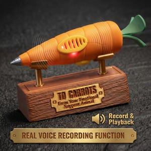 May include: An orange carrot-shaped device with a silver tip, green leaves, and a speaker. It sits on a wooden base with a gold plaque that reads "TO CARROTS From Your Emotional Support Animal." The text "Record & Playback" and "REAL VOICE RECORDING FUNCTION" are also visible.