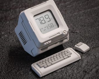 May include: A white retro-style computer with a screen displaying 78.9°F and 58% humidity. It includes a matching keyboard and mouse. The design is reminiscent of vintage technology.