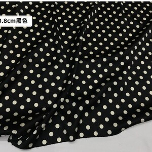 Peut inclure: Tissu noir &agrave; pois blancs. Les pois mesurent environ 0,8 cm de diam&egrave;tre. Le tissu est drap&eacute;, cr&eacute;ant des plis et des ombres. Le motif g&eacute;n&eacute;ral est un design &agrave; pois classique.