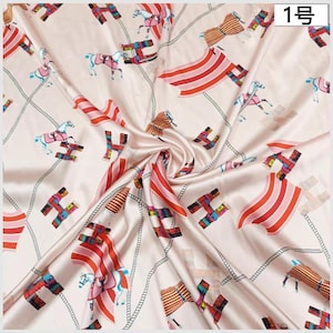 May include: A cream silk scarf featuring a repeating pattern of horses, the letter "H", and striped elements in red, pink, and brown. The design includes a rope-like border. The number "1" is in the top right corner.