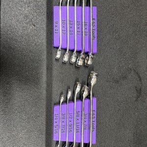 Può includere: Un set di chiavi cromate, organizzate su un supporto in schiuma viola. Le chiavi sono etichettate con misure come 1/4 x 5/16 e 3/4 x 7/8 pollici. Il supporto è etichettato con "E&S Tools".