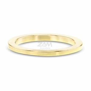 May include: A gold-colored ring with a flat, rounded design. The ring is made of a shiny, polished metal and is set against a white background. The text "ZAM Jewellers" is visible on the ring.