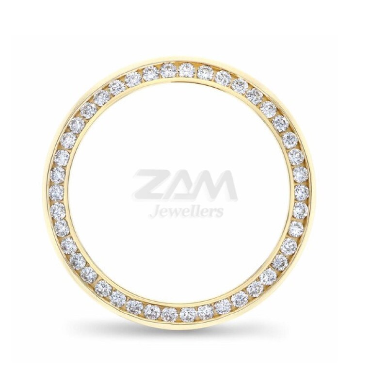 May include: A gold-colored, circular jewelry piece with a ring of small, clear gemstones set around the outer edge. The center of the piece has the text "ZAM Jewellers" in a stylized font.