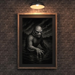 以下が含まれることがあります： 水から現れる黒いラグーンの生き物の額装された白黒イラスト。アートワークは木製のフレームに入っており、レンガの壁に掛けられており、単一のオーバーヘッドライトで照らされています。
