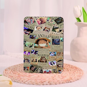 May include: A rectangular tablet case featuring a collage of One Piece character wanted posters. The design includes various anime figures with the text WANTED, DEAD OR ALIVE, and specific character names like Monkey D. Luffy and God Usopp.