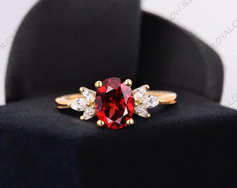 Anillo de compromiso con granate rojo natural en oro macizo de 14 quilates. Granate ovalado con diamantes laterales. Piedra de nacimiento de enero.