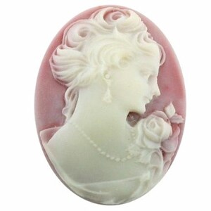 May include: A white cameo featuring a detailed carving of a woman holding a rose. The cameo is set in a pink oval-shaped base.