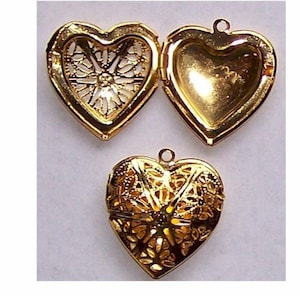 May include: Three gold-tone heart-shaped locket pendants. Each locket has a filigree design and a hinged opening.