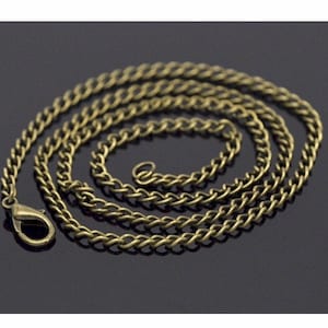 May include: A gold-toned chain necklace with a lobster clasp closure. The chain is made of a twisted, curb link design.