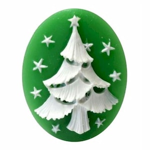 May include: A green oval-shaped Christmas ornament with a white Christmas tree and white star accents. The tree has detailed, layered branches and a star on top. The ornament is a festive holiday decoration.