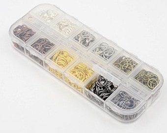 May include: A clear plastic storage box with 10 compartments filled with various sizes of jump rings. The jump rings are silver, gold, and bronze.