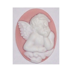 May include: A white ceramic cameo of a cherub angel with wings, set in a pink oval background.