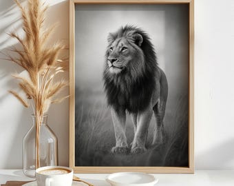 May include: A framed black and white wall art print featuring a standing lion with a full mane, positioned next to a clear glass vase containing dried pampas grass, a white ceramic coffee cup on a saucer, and a small white bowl on a table.