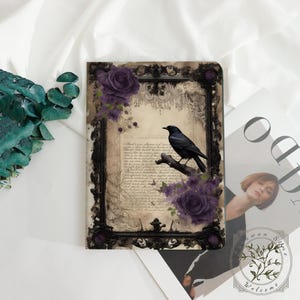 May include: A decorative notebook featuring a black raven perched on a branch, set against a vintage parchment background. The design includes purple roses and ornate black framing, creating a gothic aesthetic.