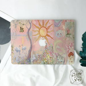 May include: A laptop hard shell case featuring a pastel-toned collage of illustrations including a sun, a crescent moon, two white swans on a lake, a fawn, a cat, a mouse with a mushroom hat, a whale, and a tree with hanging rabbits.