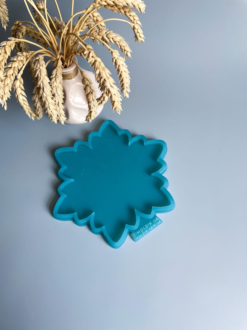 Pu&ograve; includere: Uno stampo in silicone turchese a forma di fiore. Lo stampo ha un bordo smerlato e si trova su una superficie azzurra. Un piccolo vaso bianco con spighe di grano &egrave; sullo sfondo. Il testo "MOLDIK.UA MOLDIK.COM.UA" &egrave; stampato sullo stampo.