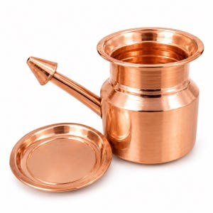 May include: A polished copper neti pot with a wide, open top and a long, tapered spout extending from the side. The vessel features a smooth, metallic finish and is accompanied by a matching circular copper lid resting flat on the surface.