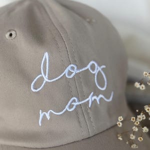 Peut inclure: Casquette de baseball beige avec l'inscription "dog mom" brod&eacute;e en blanc. La casquette a une visi&egrave;re incurv&eacute;e et un petit trou d'a&eacute;ration. Le design est simple et &eacute;l&eacute;gant, id&eacute;al pour un usage quotidien.